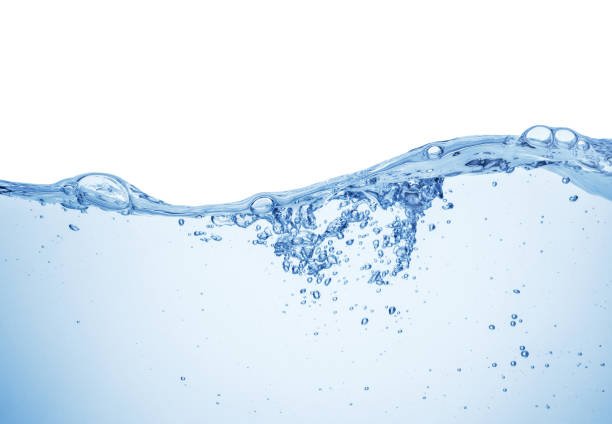 A glass of fresh water with lemon slices and ice cubes on a table, representing hydration.