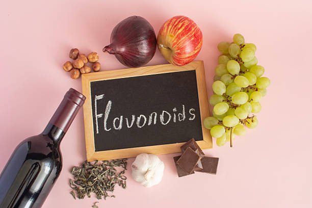 A colorful assortment of fruits, vegetables, tea, and dark chocolate highlighting rich sources of flavonoids.
