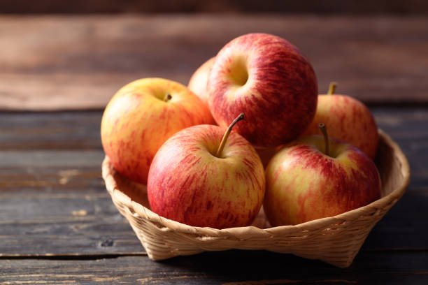 Fresh red and green apples displayed in a basket, highlighting their vibrant colors and crisp texture.