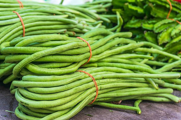 Fresh green long beans with slender, elongated shape and vibrant color.