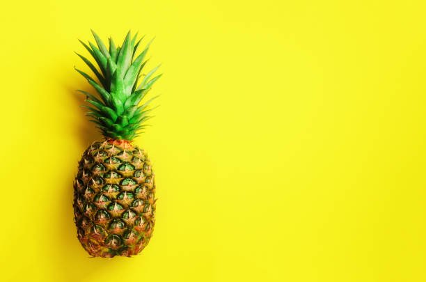 Fresh pineapple slices and chunks showing bright yellow flesh and spiky skin.